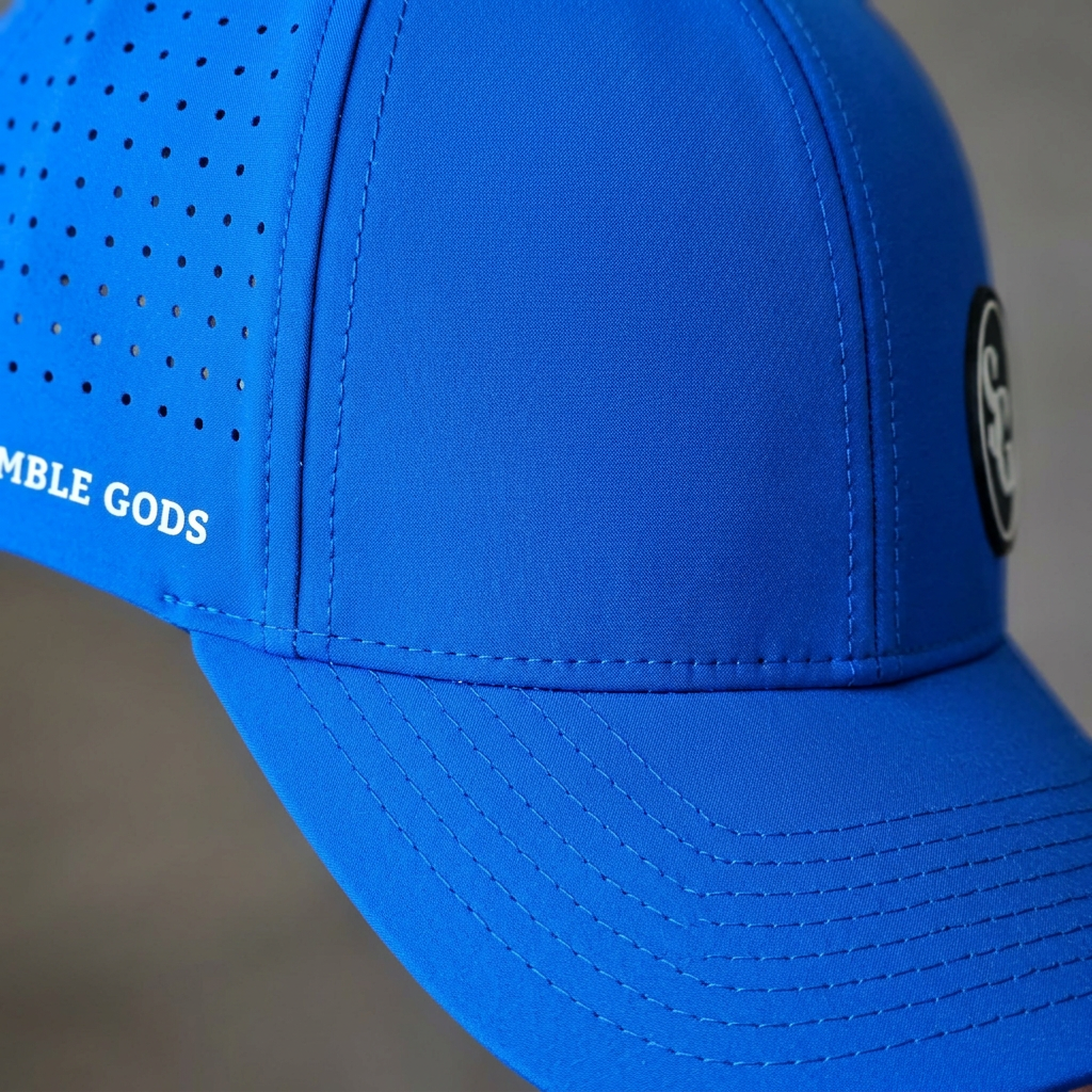 Close-up of the blue Scramble Gods hat showing fabric, panel seams, perforations, and stitched curved brim.